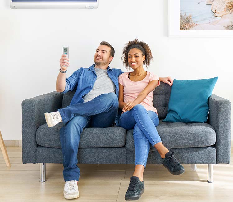 Two people sitting on a couch after a successful HVAC repair