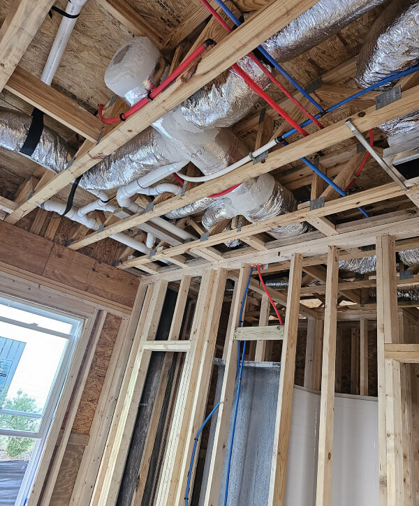 A room under construction with exposed pipes and wires in Pawleys Island