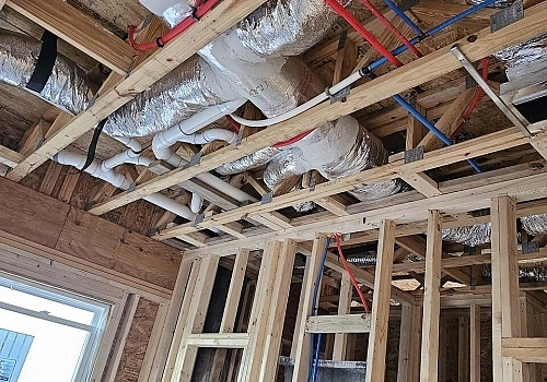 A room under construction with pipes and wiring being installed