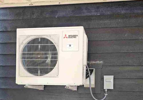 A white AC unit placed on a wall for efficient cooling in Garden City